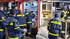 Gemeinsame Arbeit an der Sandsackfüllmaschine mit der Feuerwehr